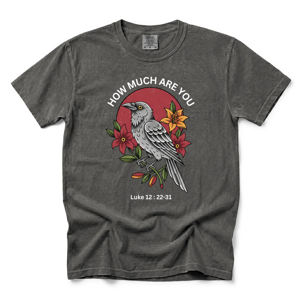 A pepper short-sleeve t-shirt with a graphic print of a raven, red flowers, and the text 'HOW MUCH ARE YOU Luke 12:22-31' on a white background.